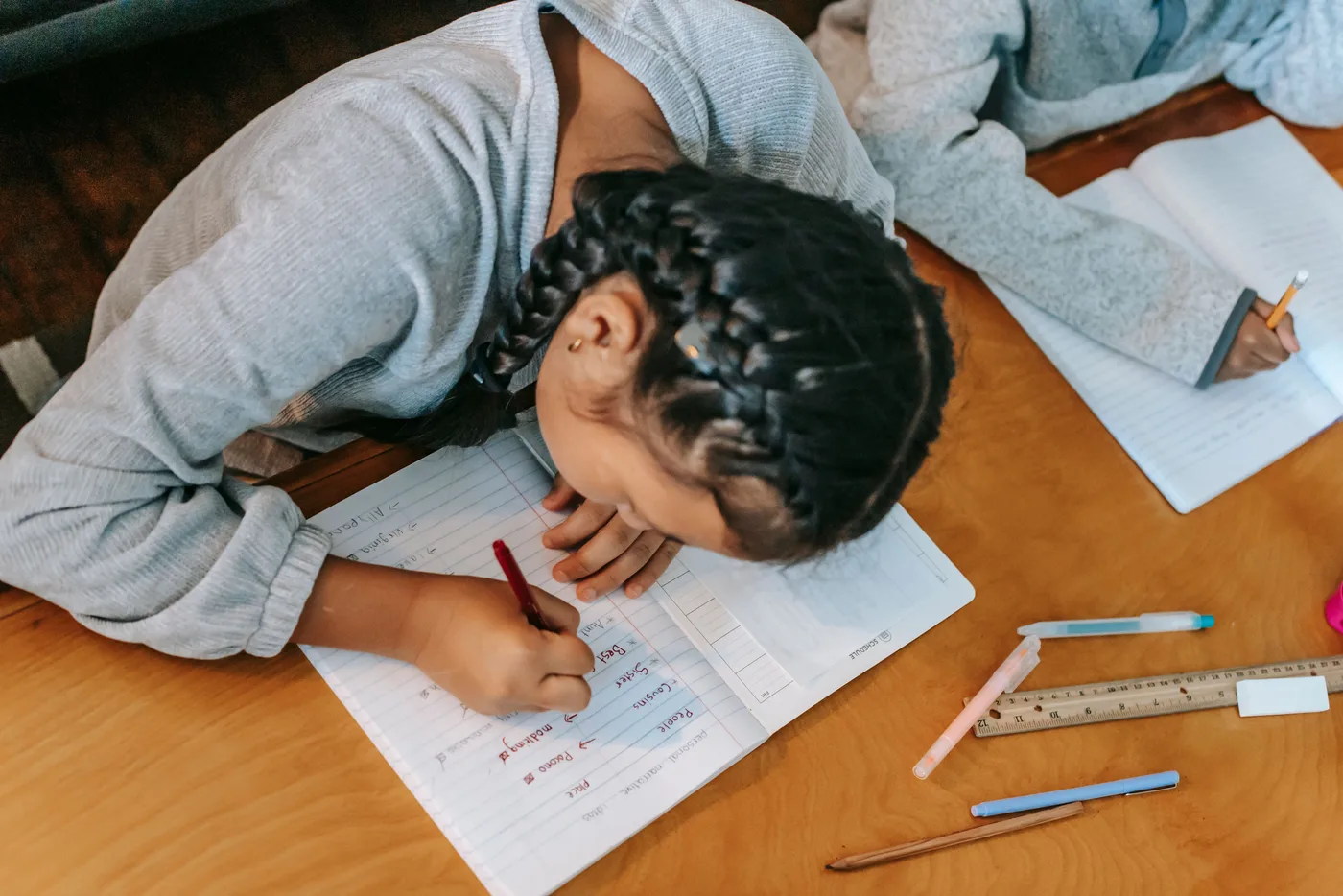 A child working through an exercise with paper and pencil at a table